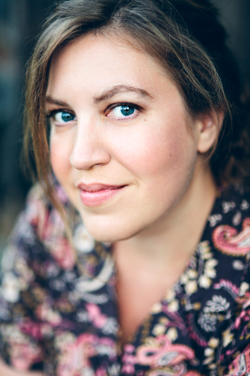 A woman wearing paisley print smiles for her headshots in Missoula Montana