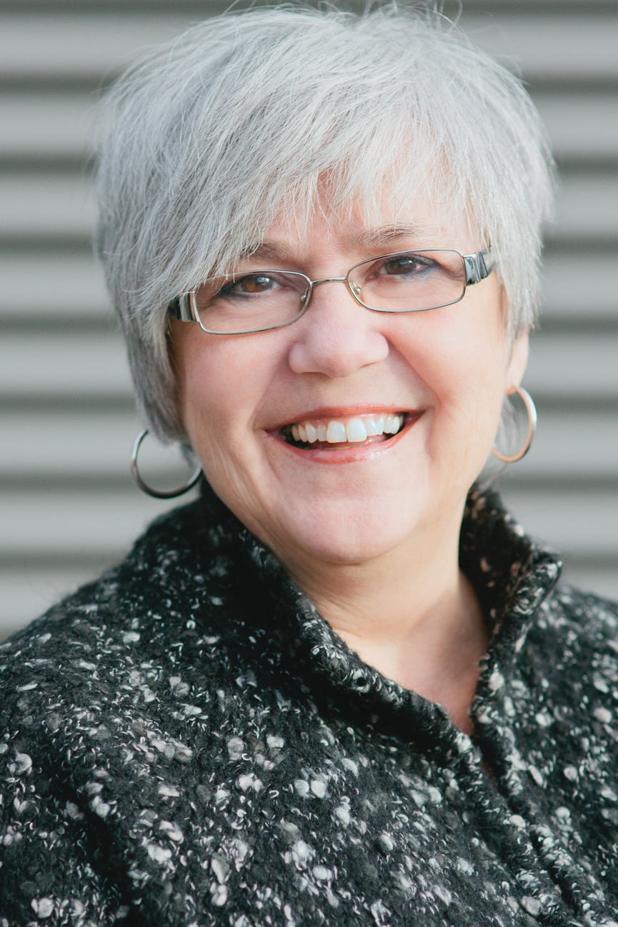 A business woman wearing a charcoal sweater smiles for her headshots in Missoula Montana