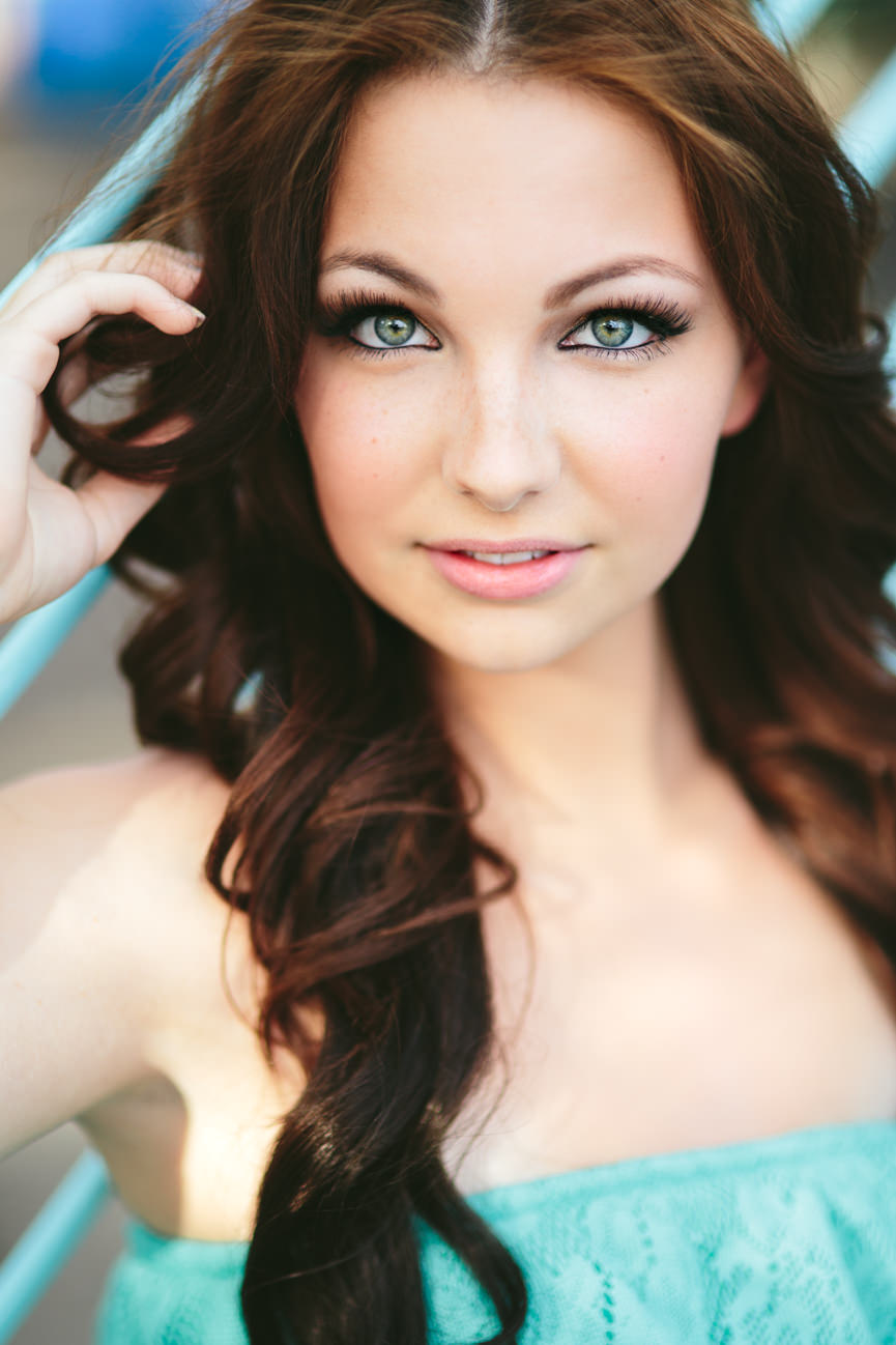 A young woman wearing turquoise smiles for her headshots in Missoula Montana