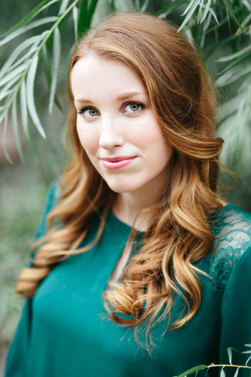 A woman wearing green smiles for her headshots in Missoula Montana