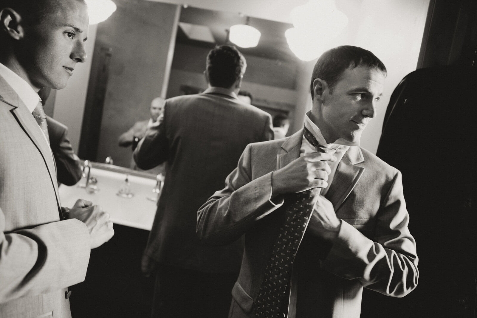 A groom ties his tie while getting ready for his wedding at the Barn on Mullan in MIssoula Montana