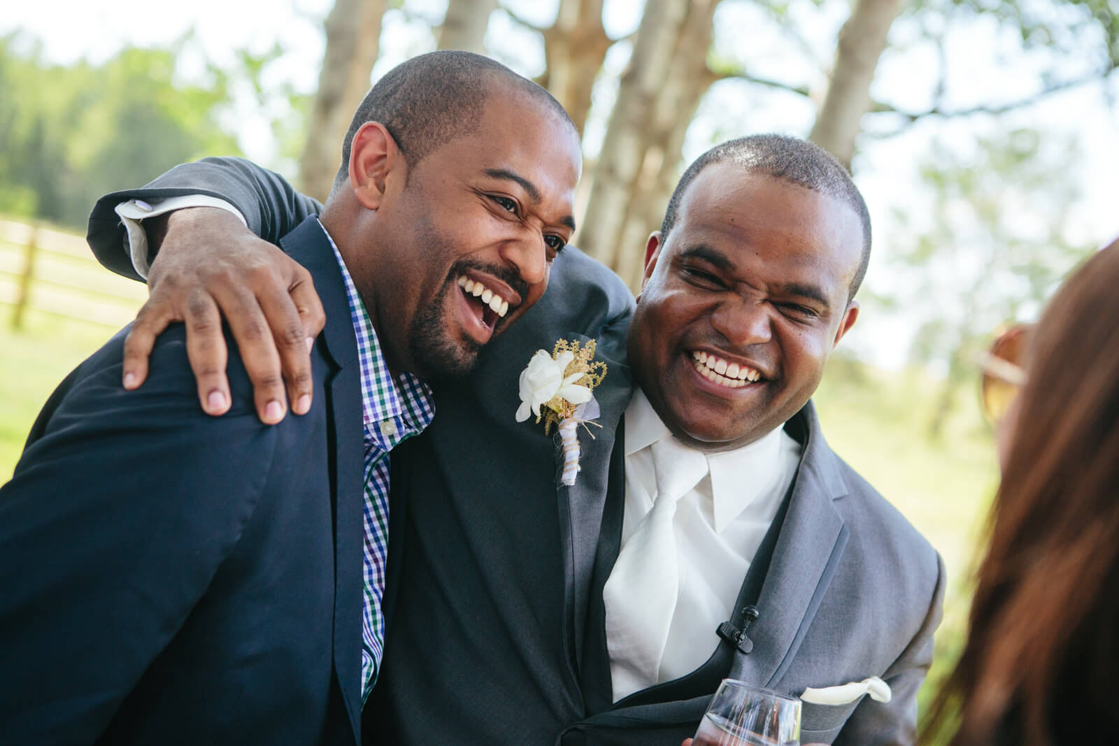 A groom laughs with a friend on his wedding day at Sky Ridge Ranch in Ronan Montana