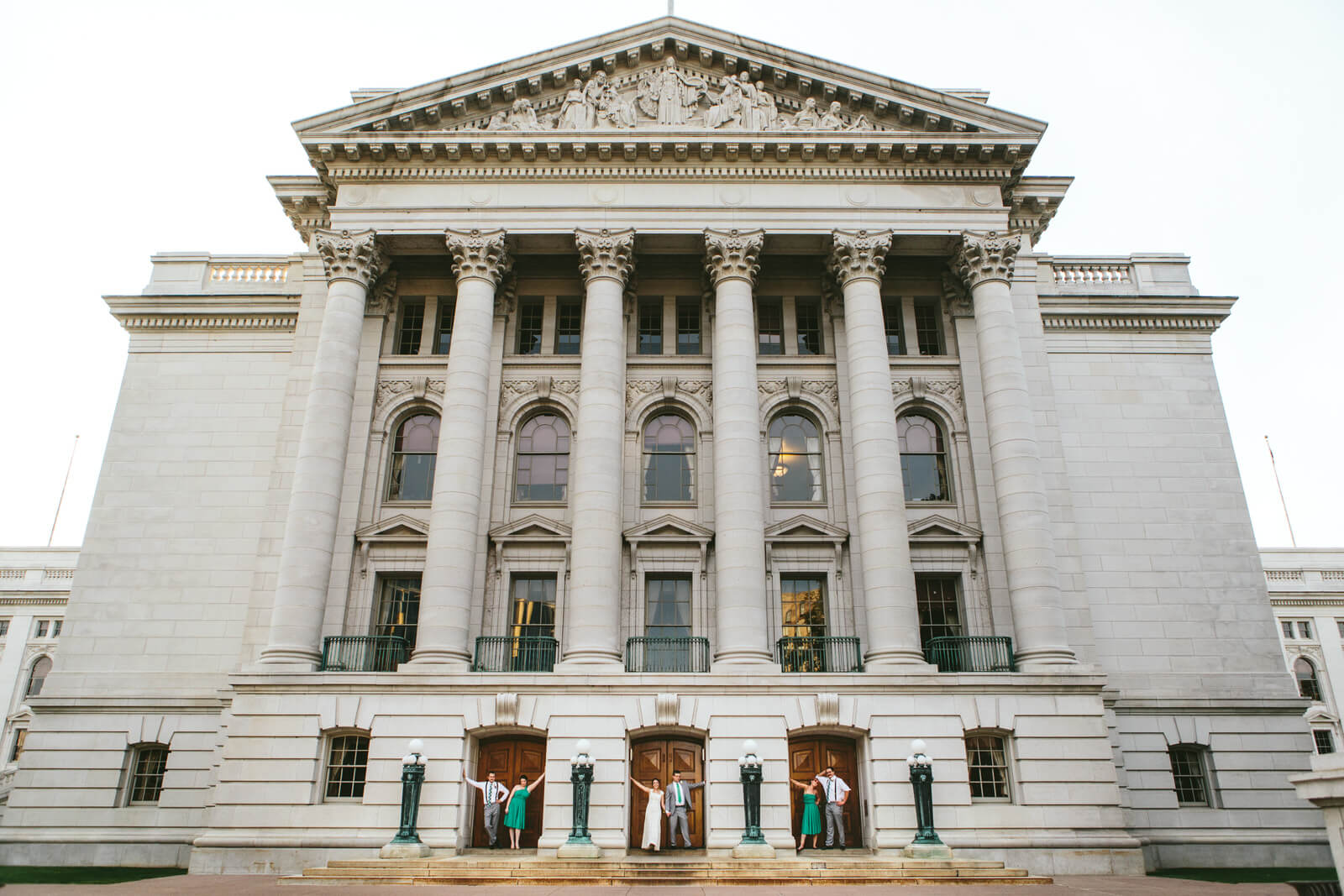 A wedding party poses in doorways at the Wisconsin state capitol in Madison Wisconsin on their wedding day