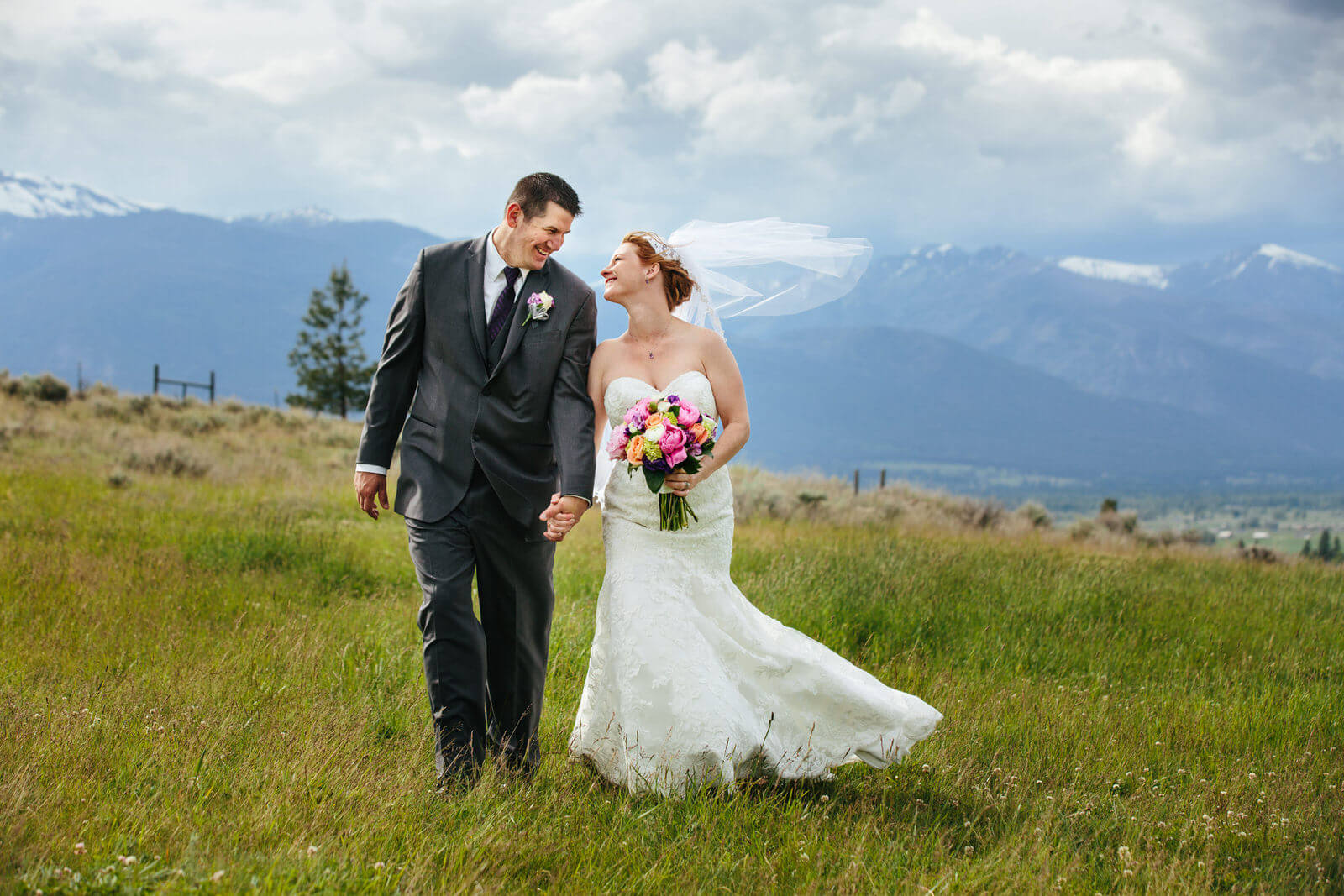 A bride and groom smile at each other during their Stone Tower Estate wedding in Stevensville Montana