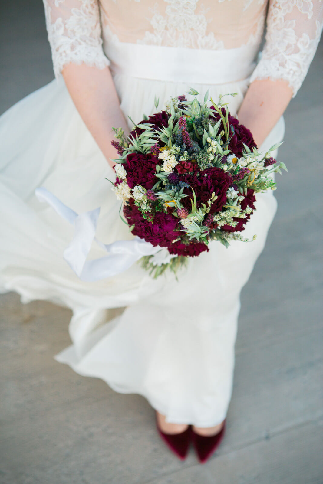 A bride holds her bouquet as the wind blows at her wedding at the Barn on Mullan in Missoula Montana