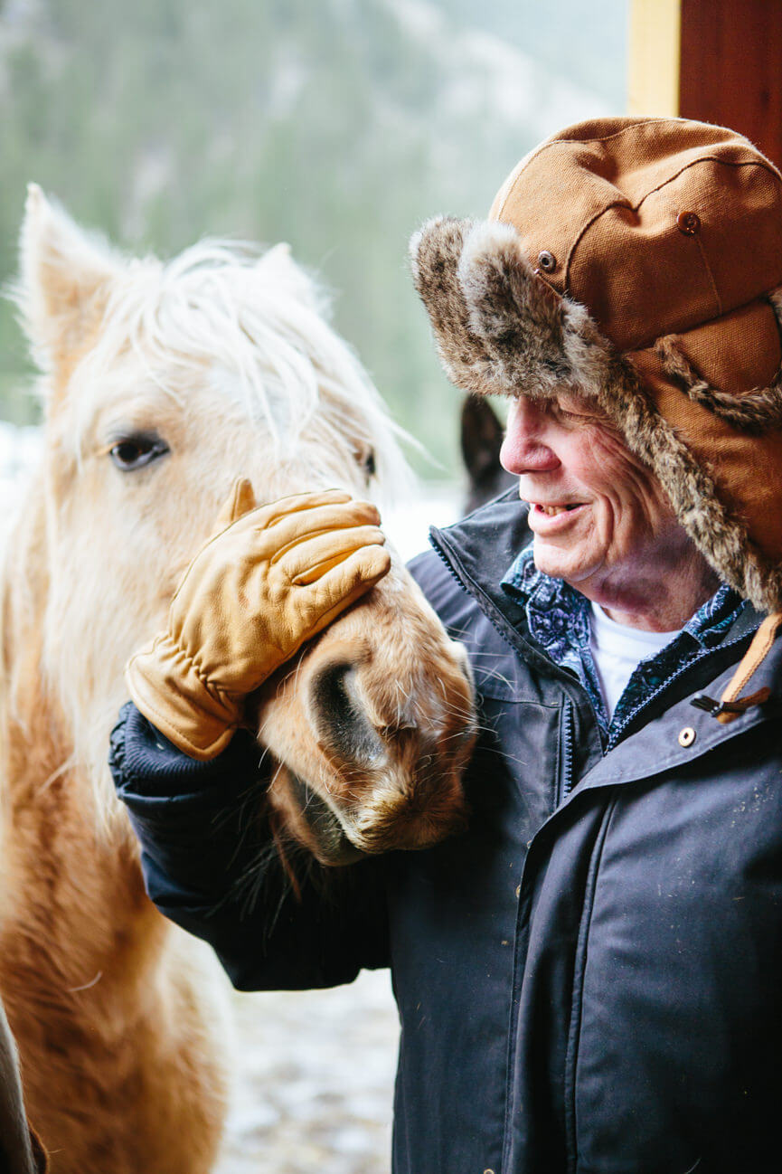 James Lee Burke smiles at one of his horses at his home in Lolo Montana