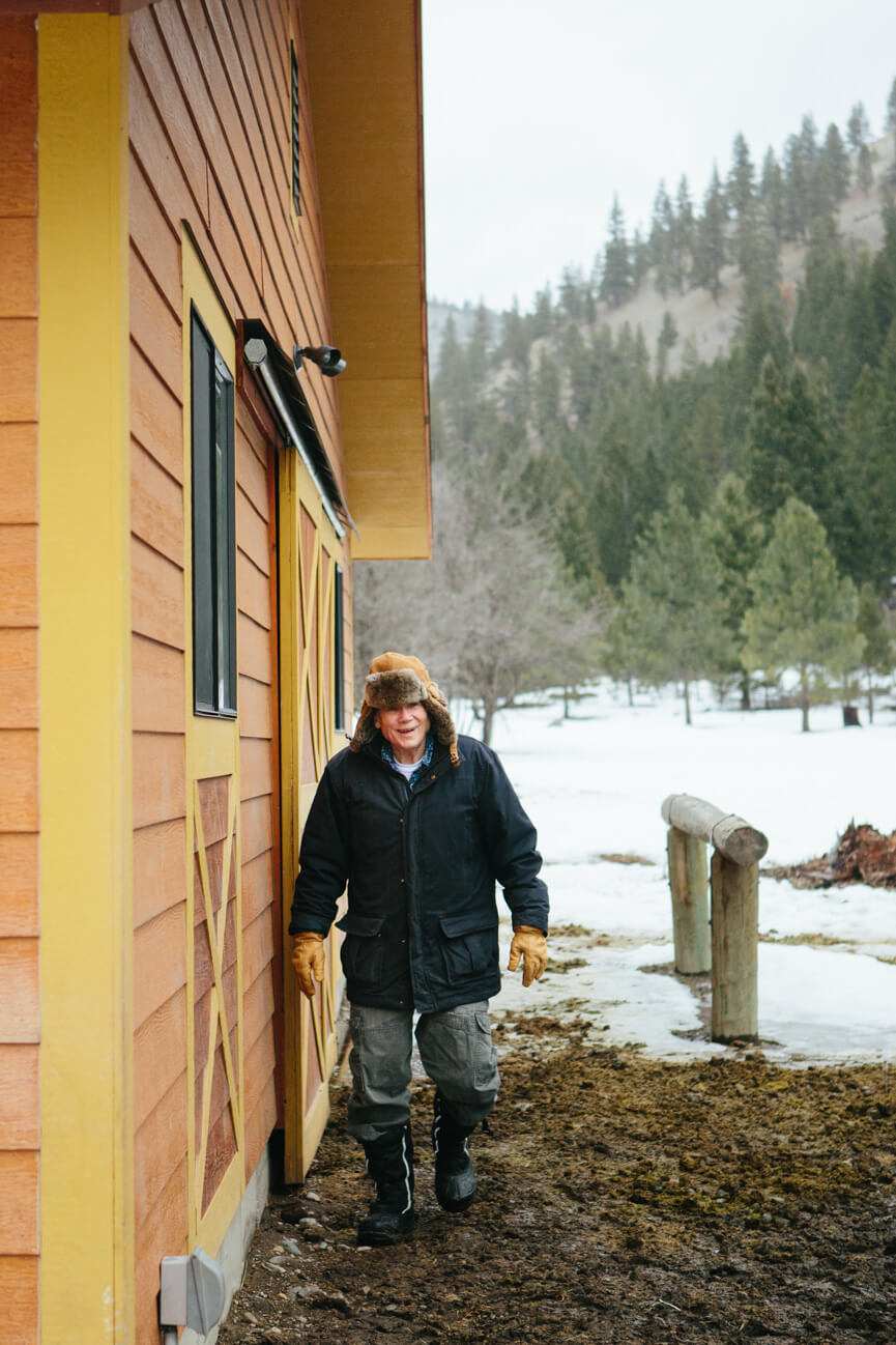 James Lee Burke walks outside of his barn at his home in Lolo Montana