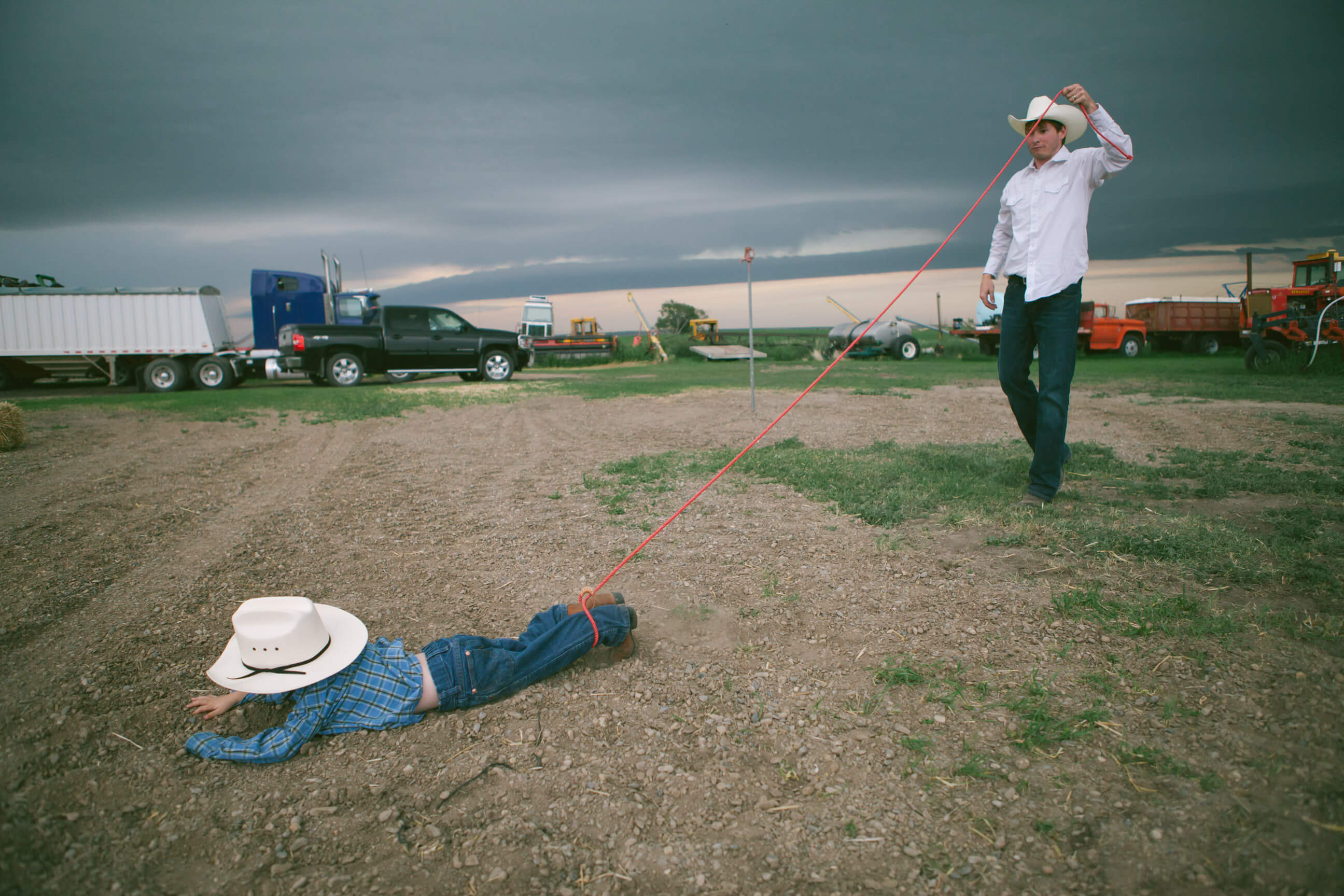 A man lassos the feet of a young boy in Conrad Montana