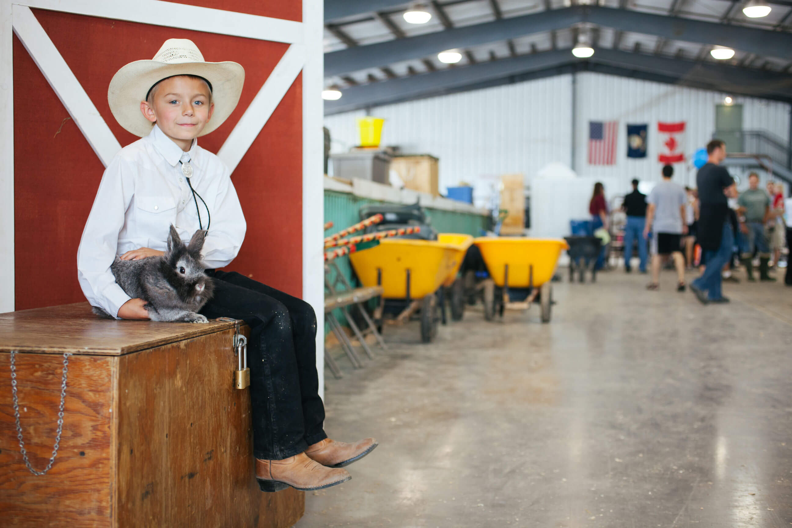 A cowboy and cowgirl sit on a fence while wearing their boots and spurs in Montana