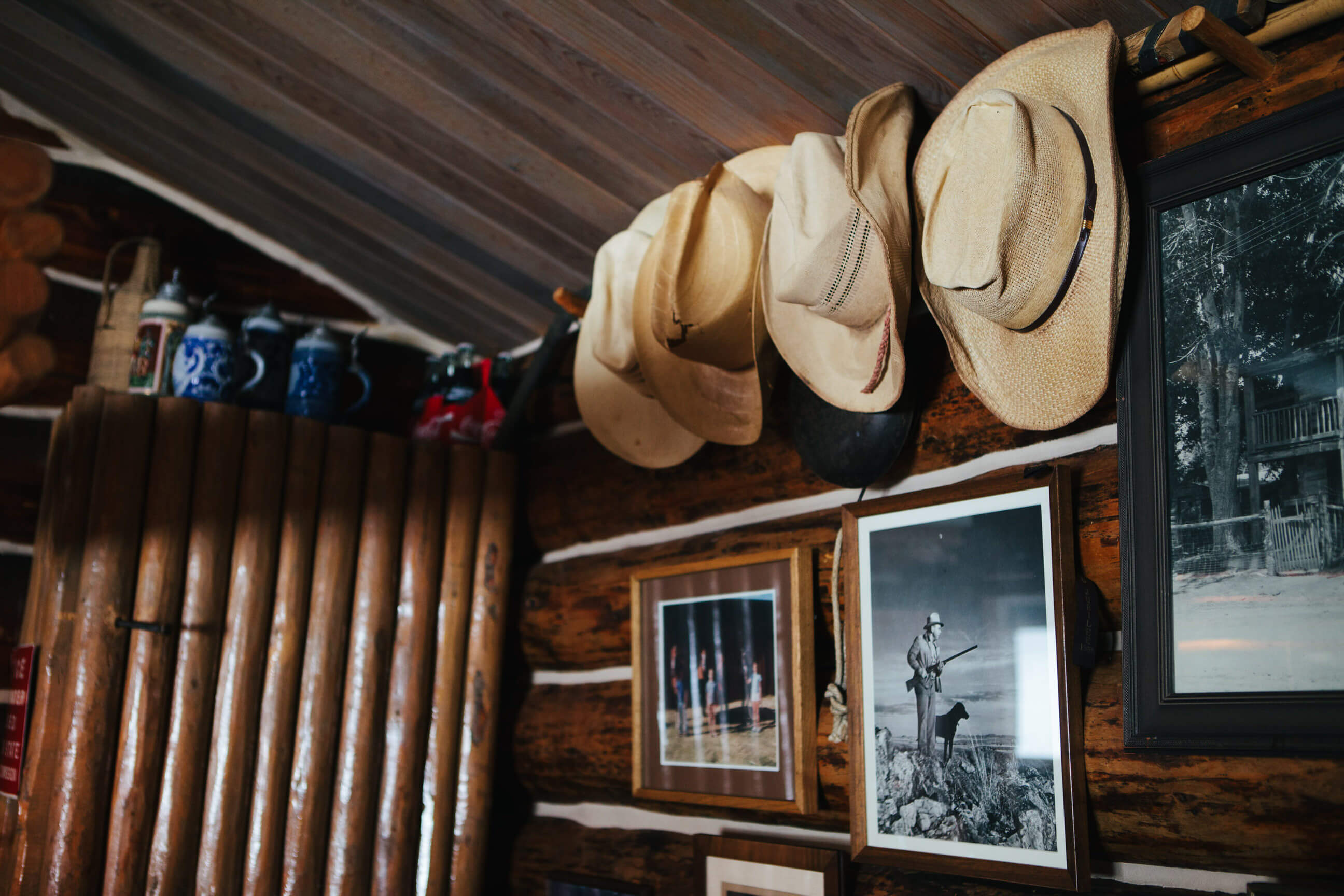 A row of hats hangs on a wall in a cabin in Phillipsburg Montana