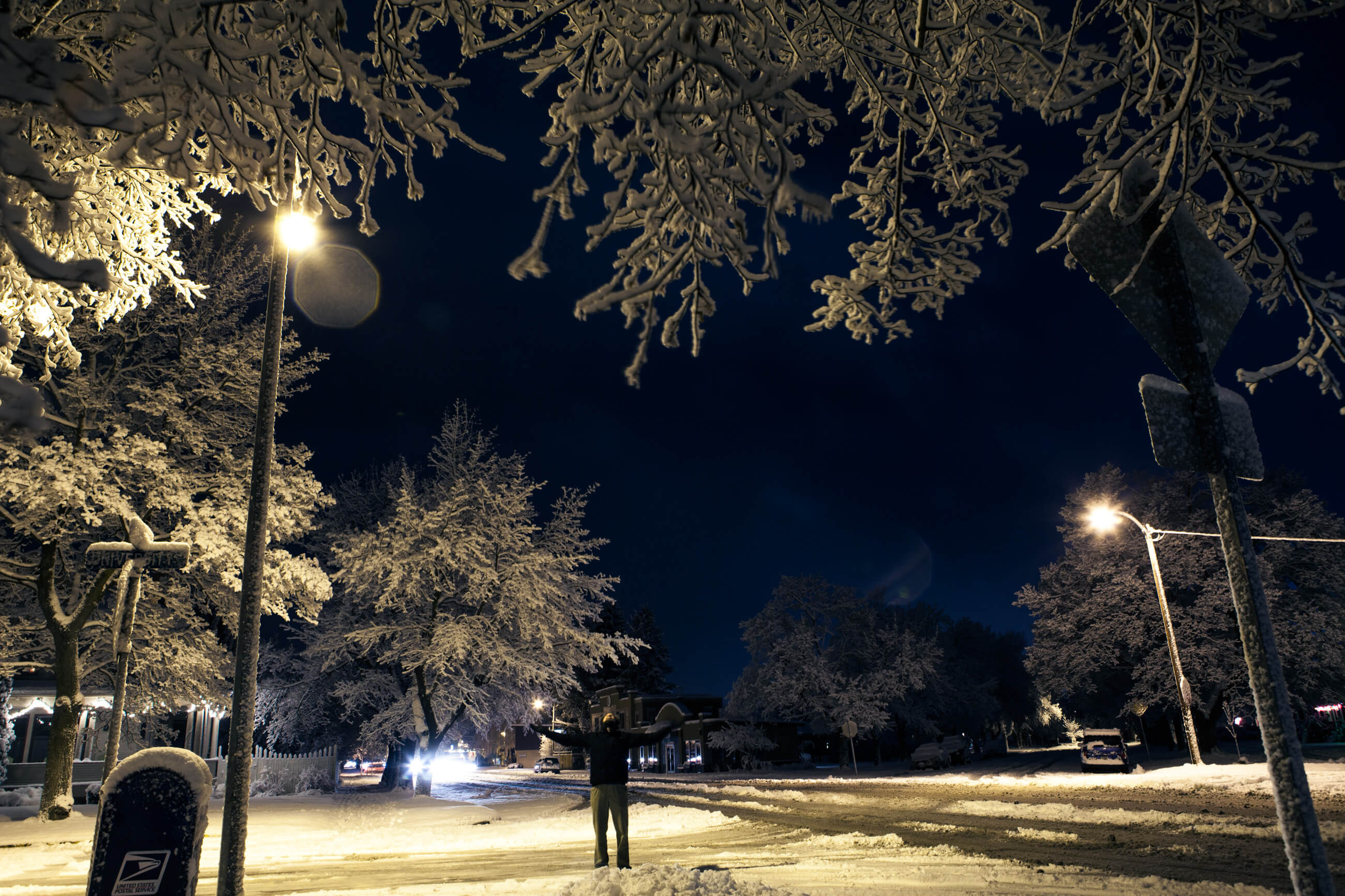 A man outstretches his arms during a snowfall in Missoula Montana