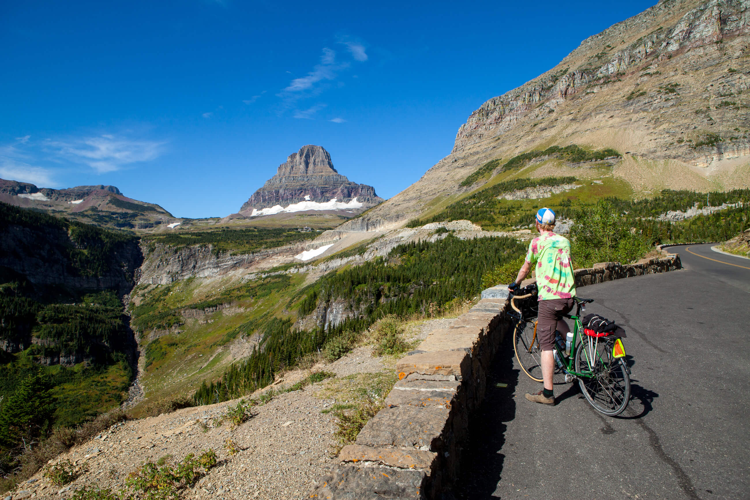 A bicyclist stops to take in the view on the Going to the Sun Road in Glacier National Park in Montana