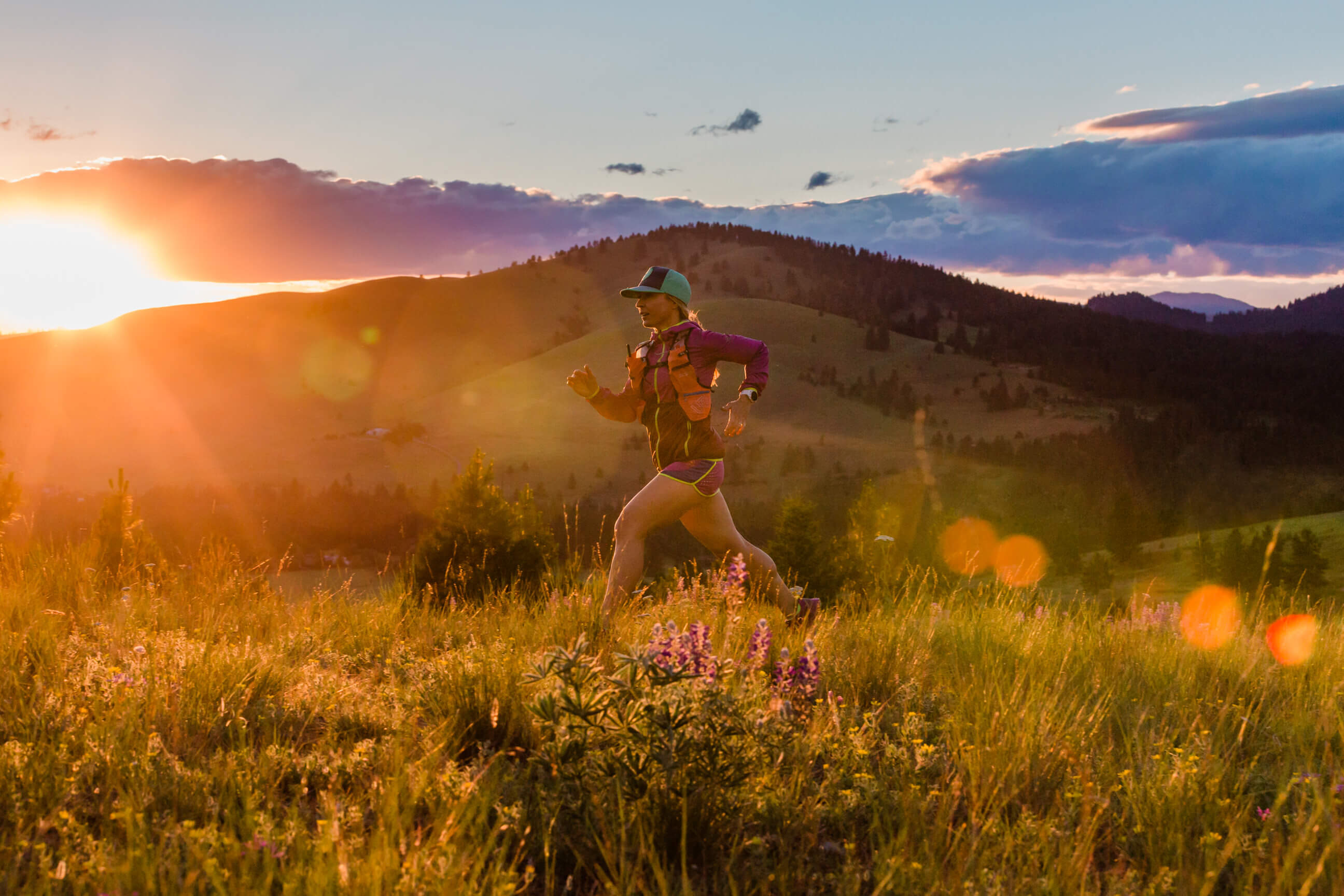 A woman trail runner sprints during her evening sunset run in Missoula Montana