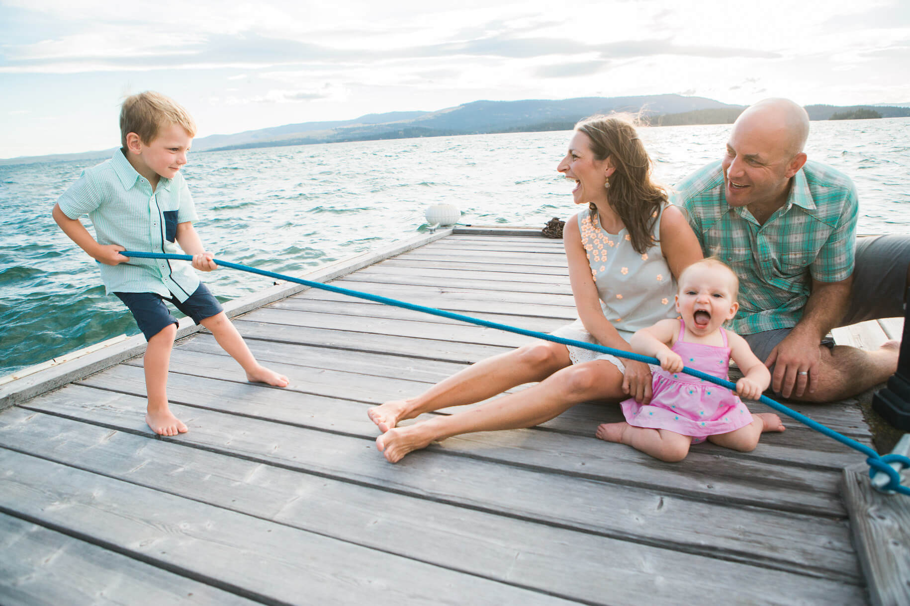 A boy pulls on a rope as his mother, father, and baby sister laugh in Polson Montana