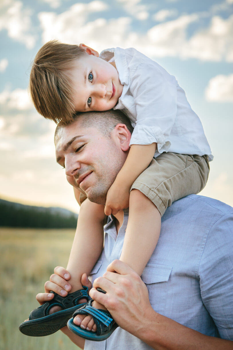 A father carries his son on his shoulders during their family photos in Missoula Montana