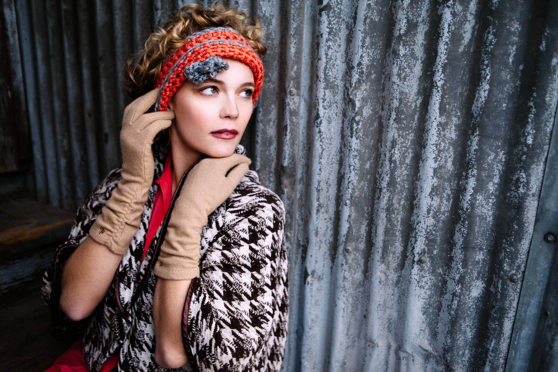 A woman leans against a corrugated metal wall during her portrait session in Missoula Montana