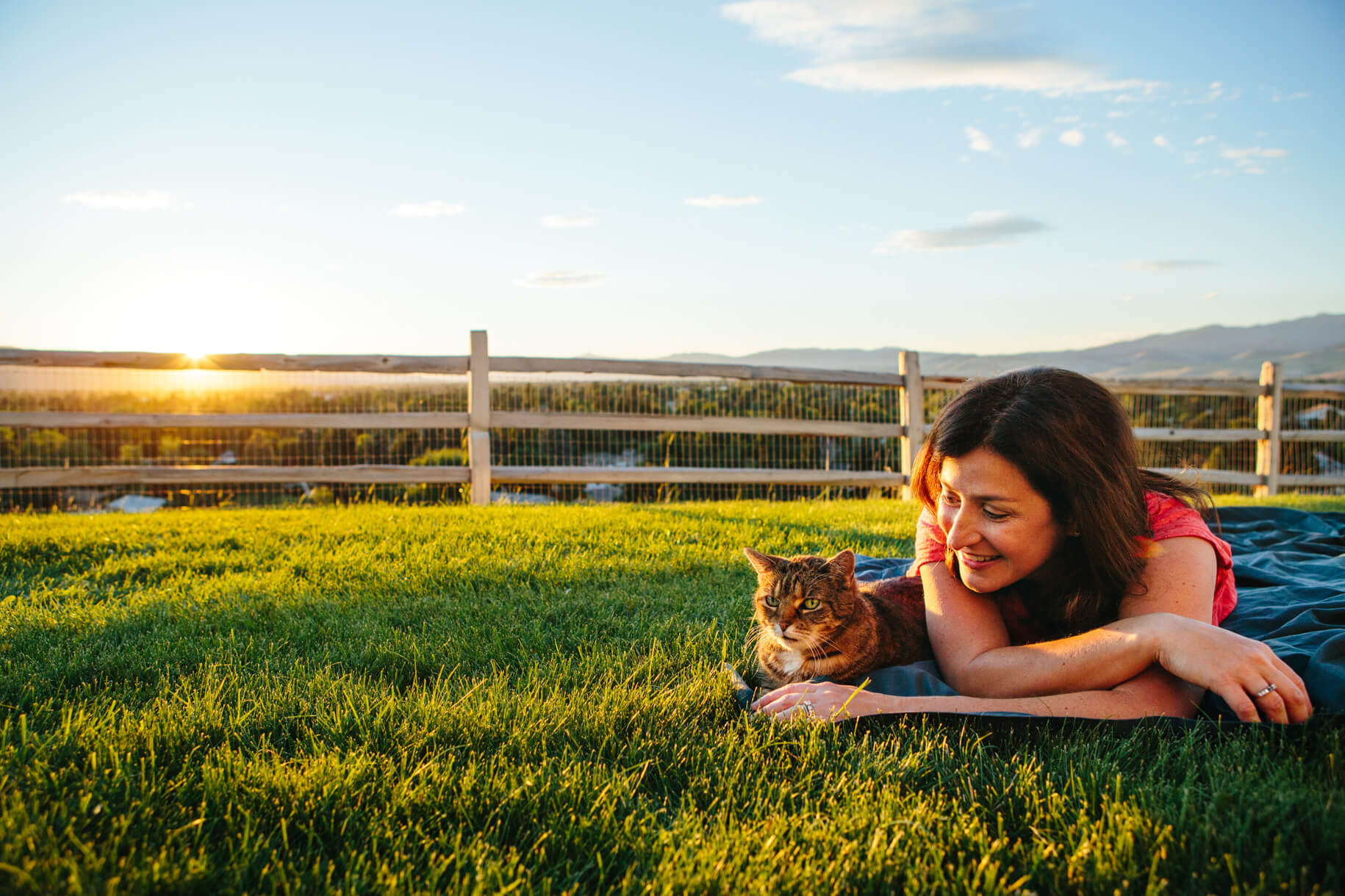 A woman lies next to her cat during her pet portrait session in Missoula Montana