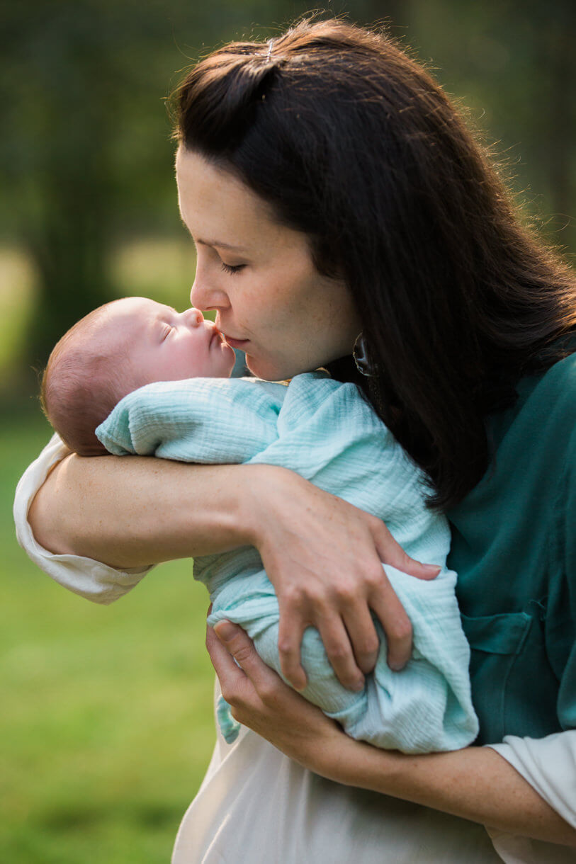 A mother kisses her newborn baby girl during their newborn portrait session in Stevensville Montana