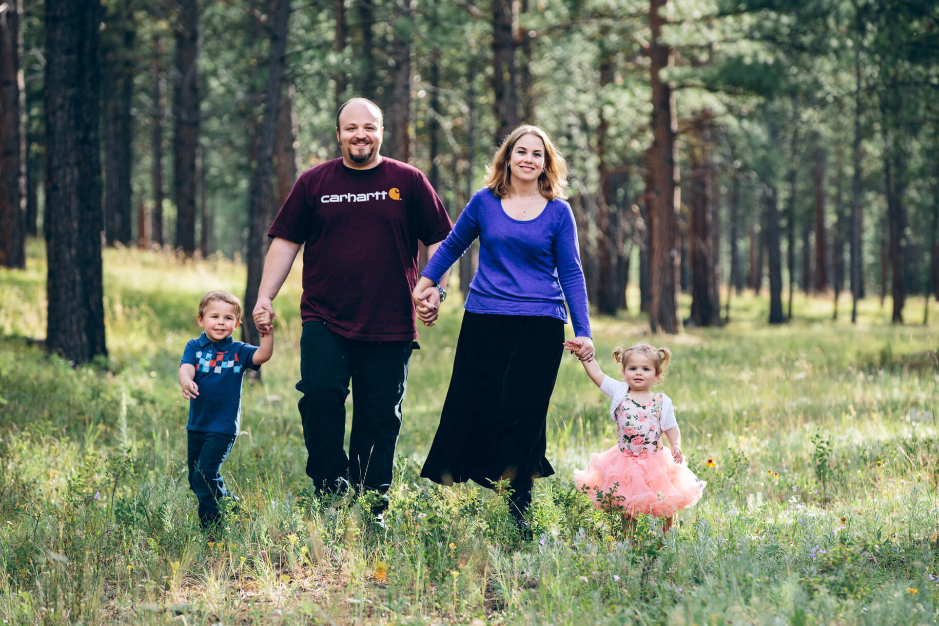 A mother, father and their son and daughter walk while holding hands during their family portraits in Potomac Montana