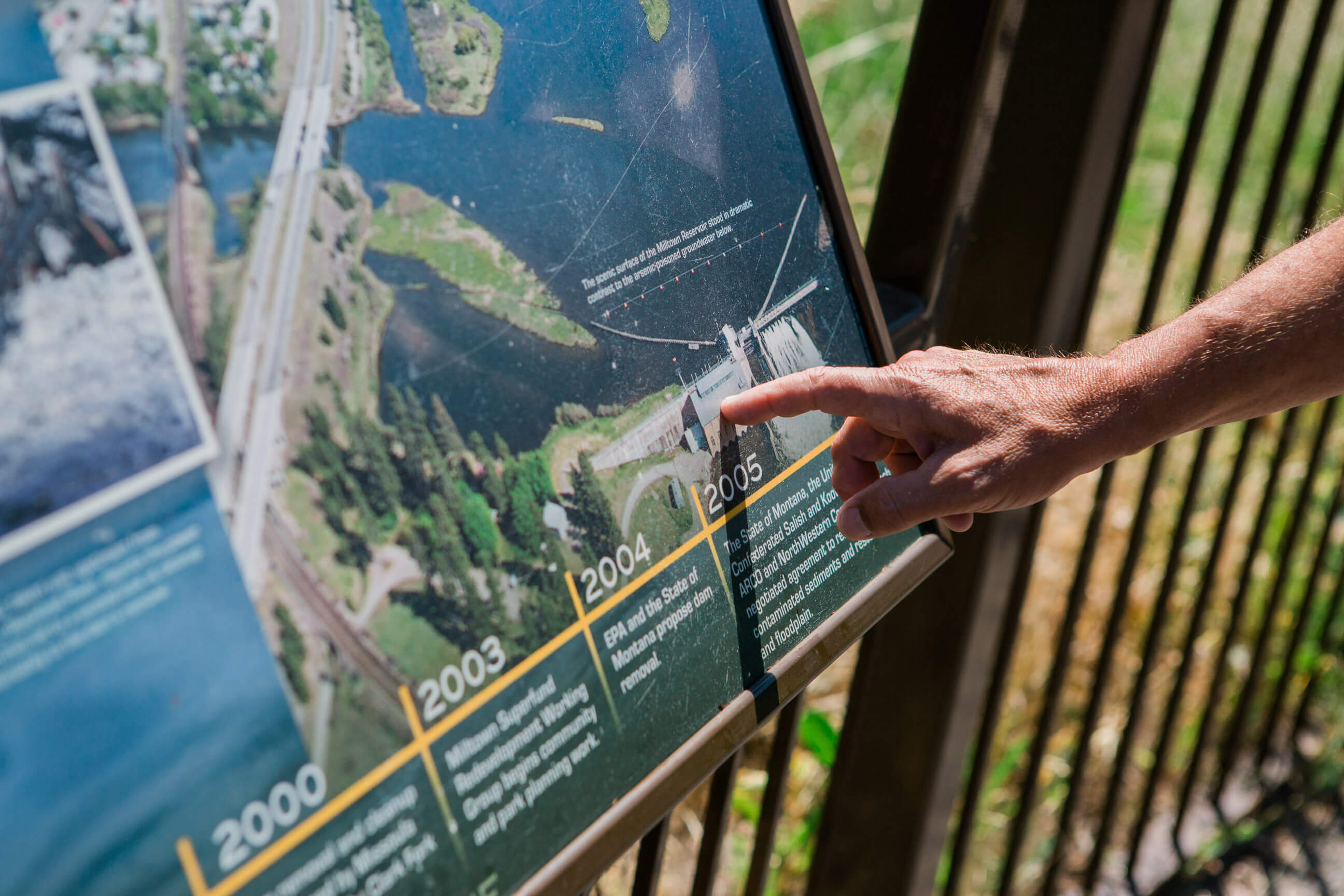 A man points at an interpretive panel at Milltown State Park in Montana