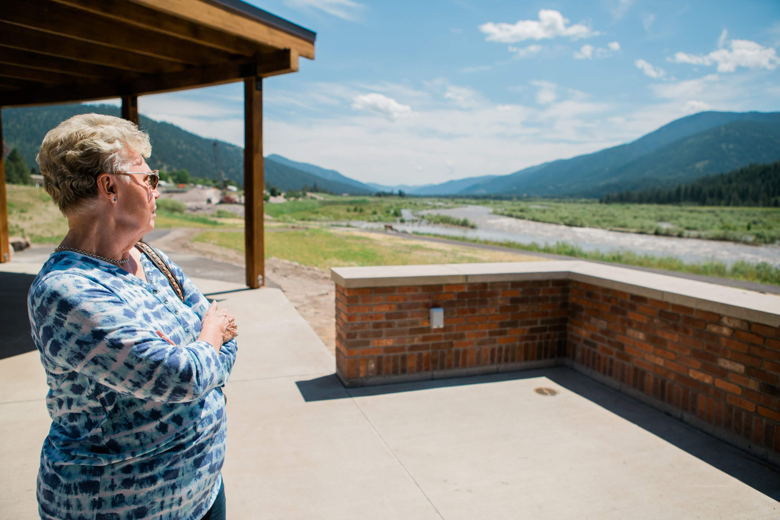 A woman looks out over a flood plain and mountains at Milltown State Park in Montana