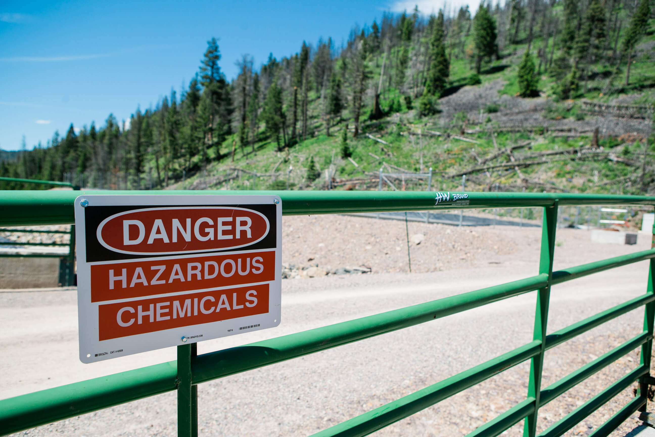 A danger sign on a gate warns people there are hazardous chemicals nearby