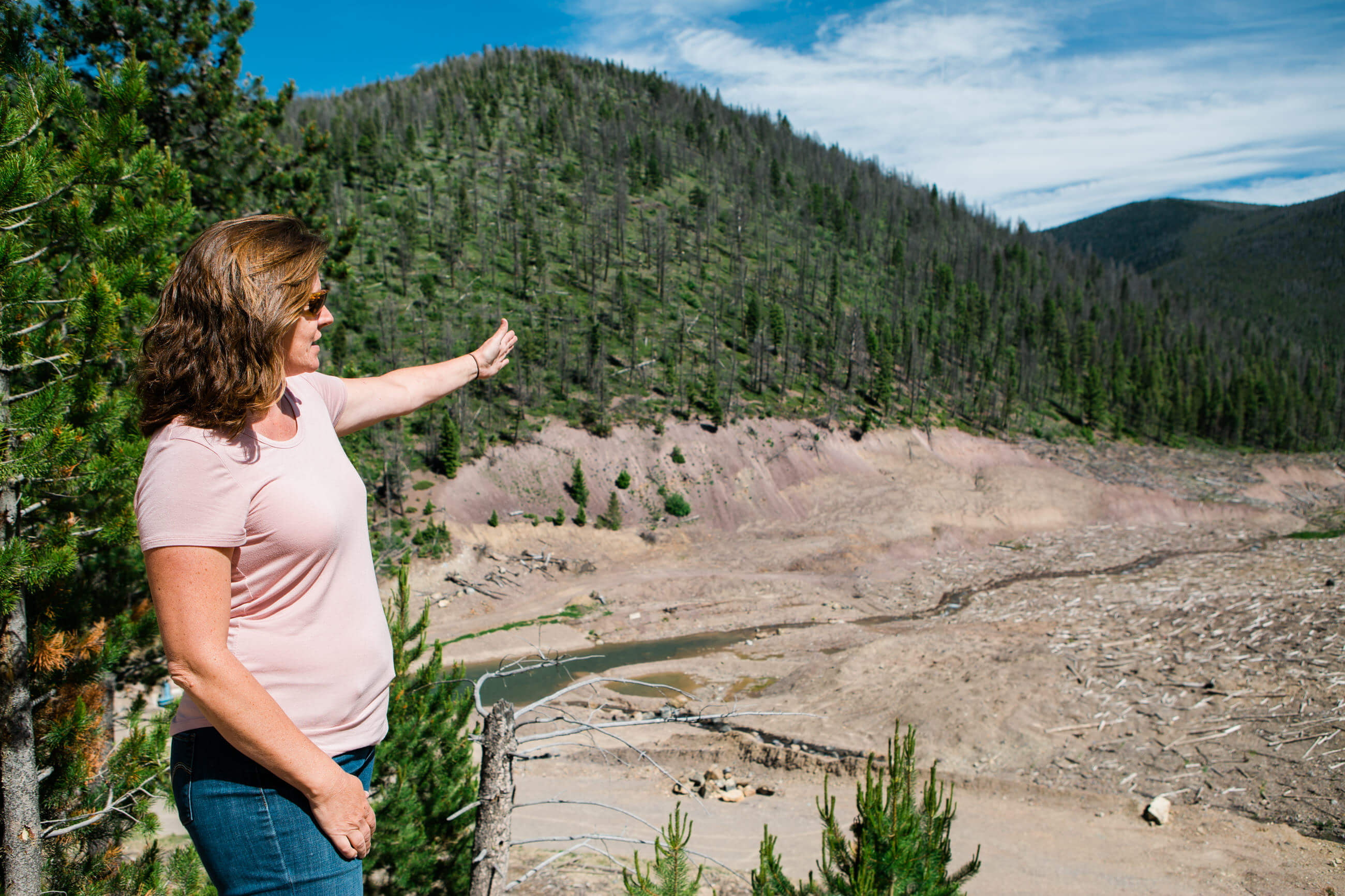 A woman gestures out over the old Mike Horse Dam site in Montana