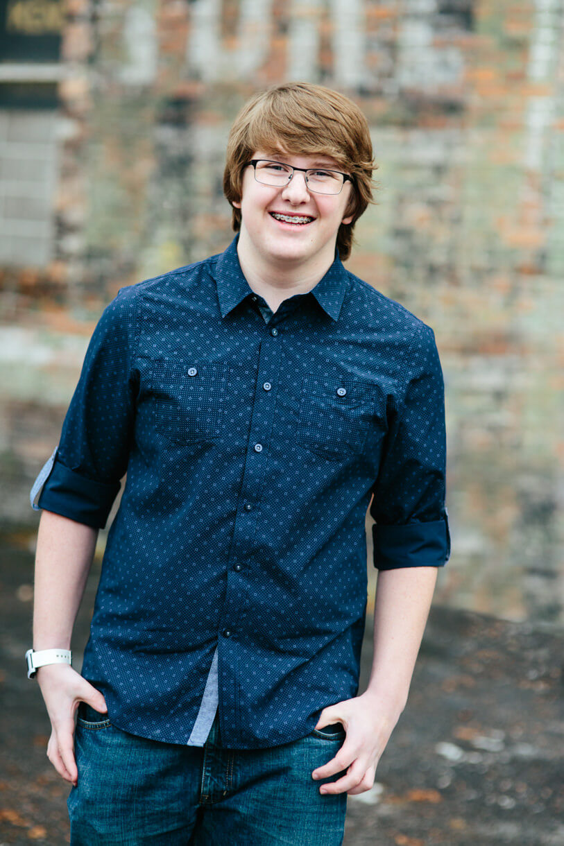 A high school senior boy smiles during his senior portraits in Missoula Montana