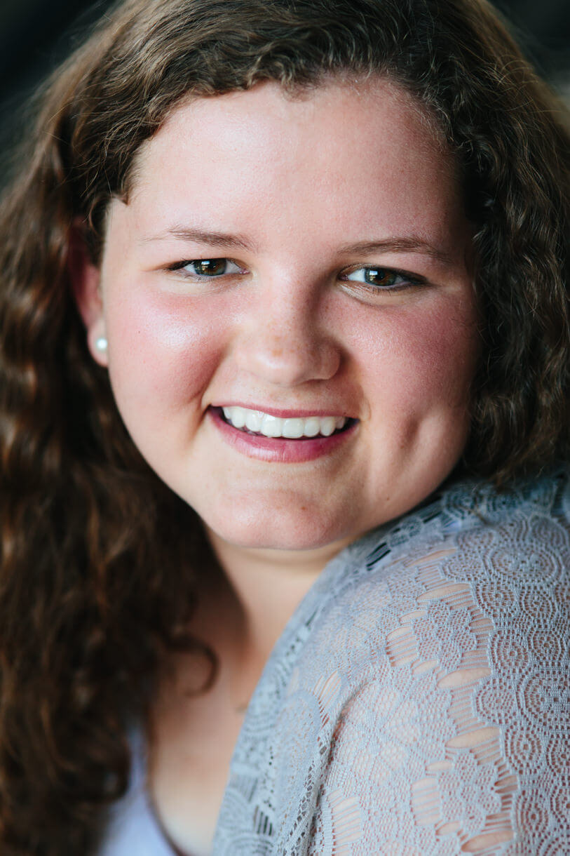 A high school senior girl smiles at the camera during her senior photos in Missoula Montana