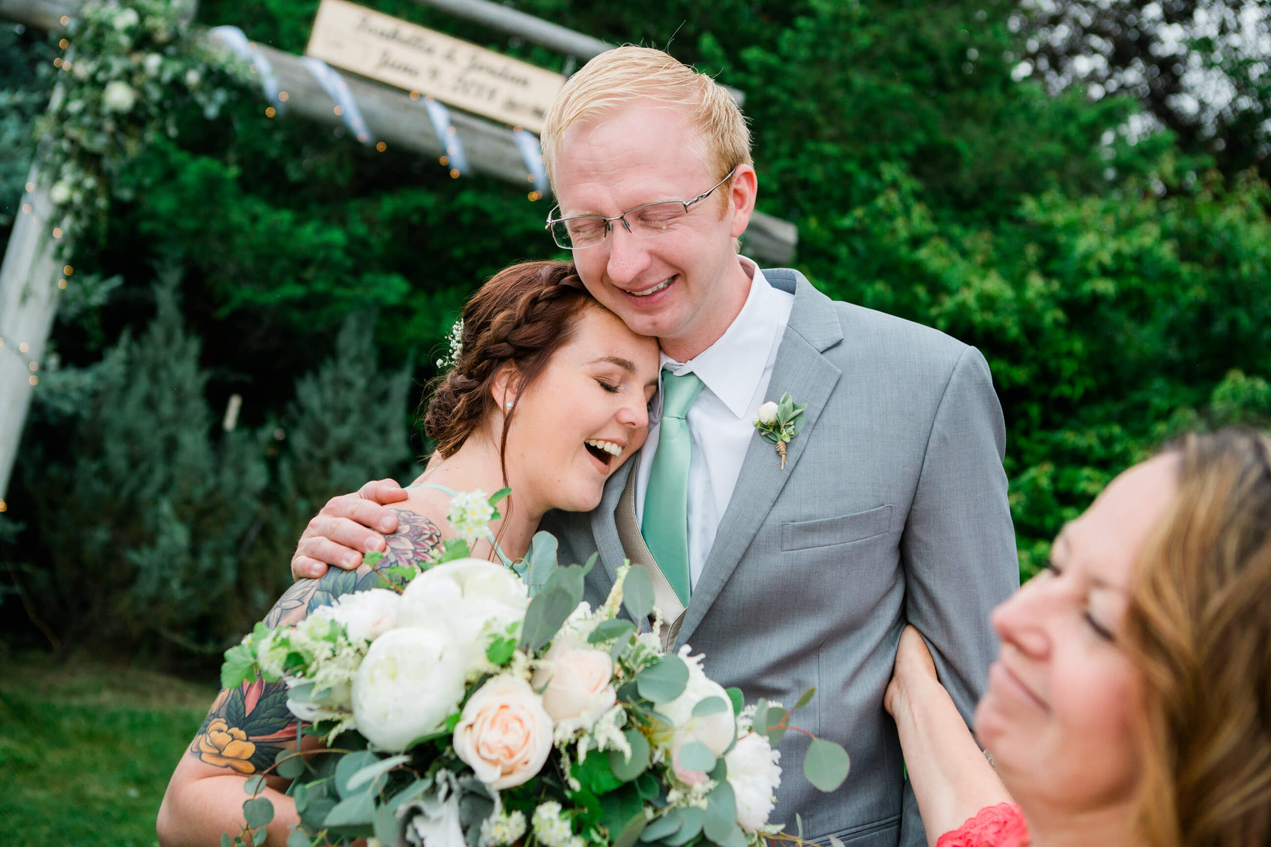 The maid of honor and best man hug and cry together during a wedding in MIssoula Montana