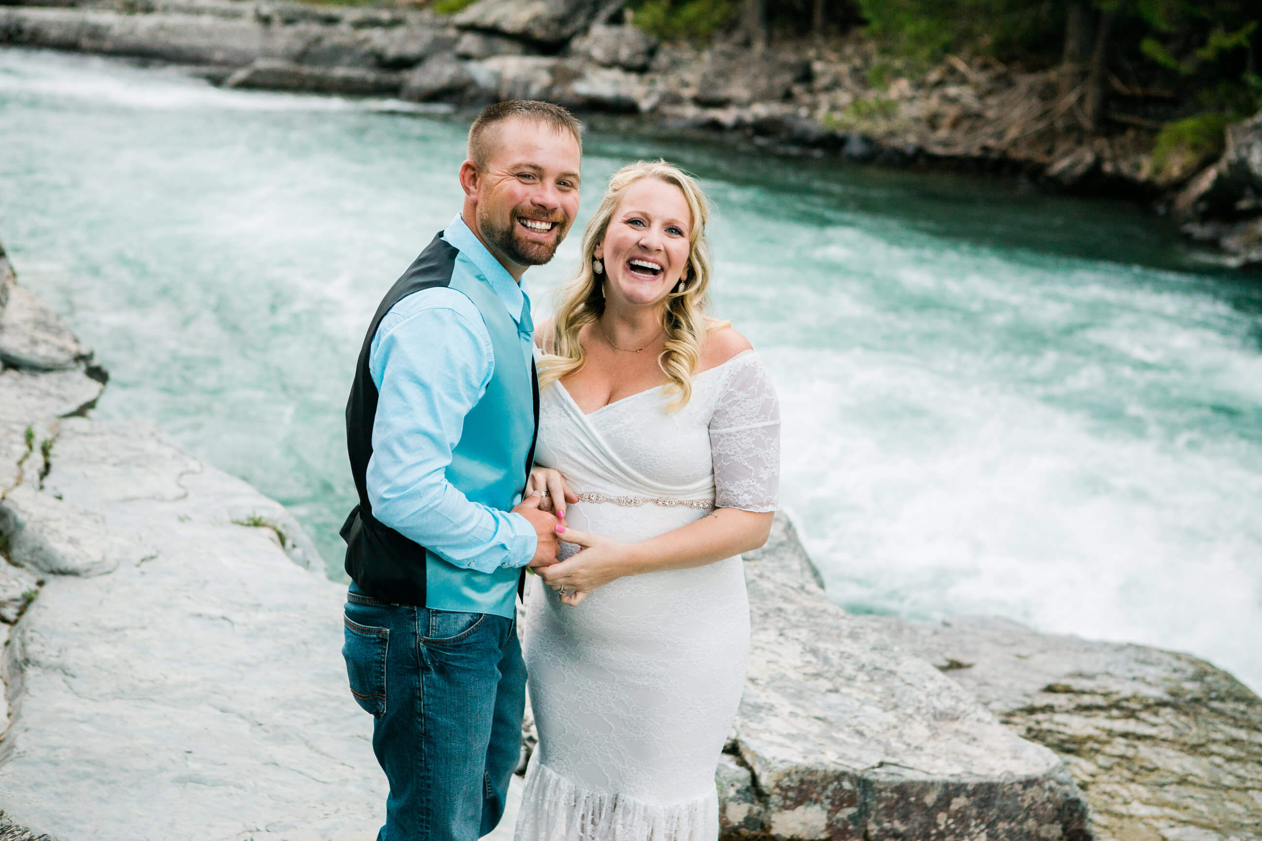 A bride and groom laugh and smile during their elopement in Glacier National Park
