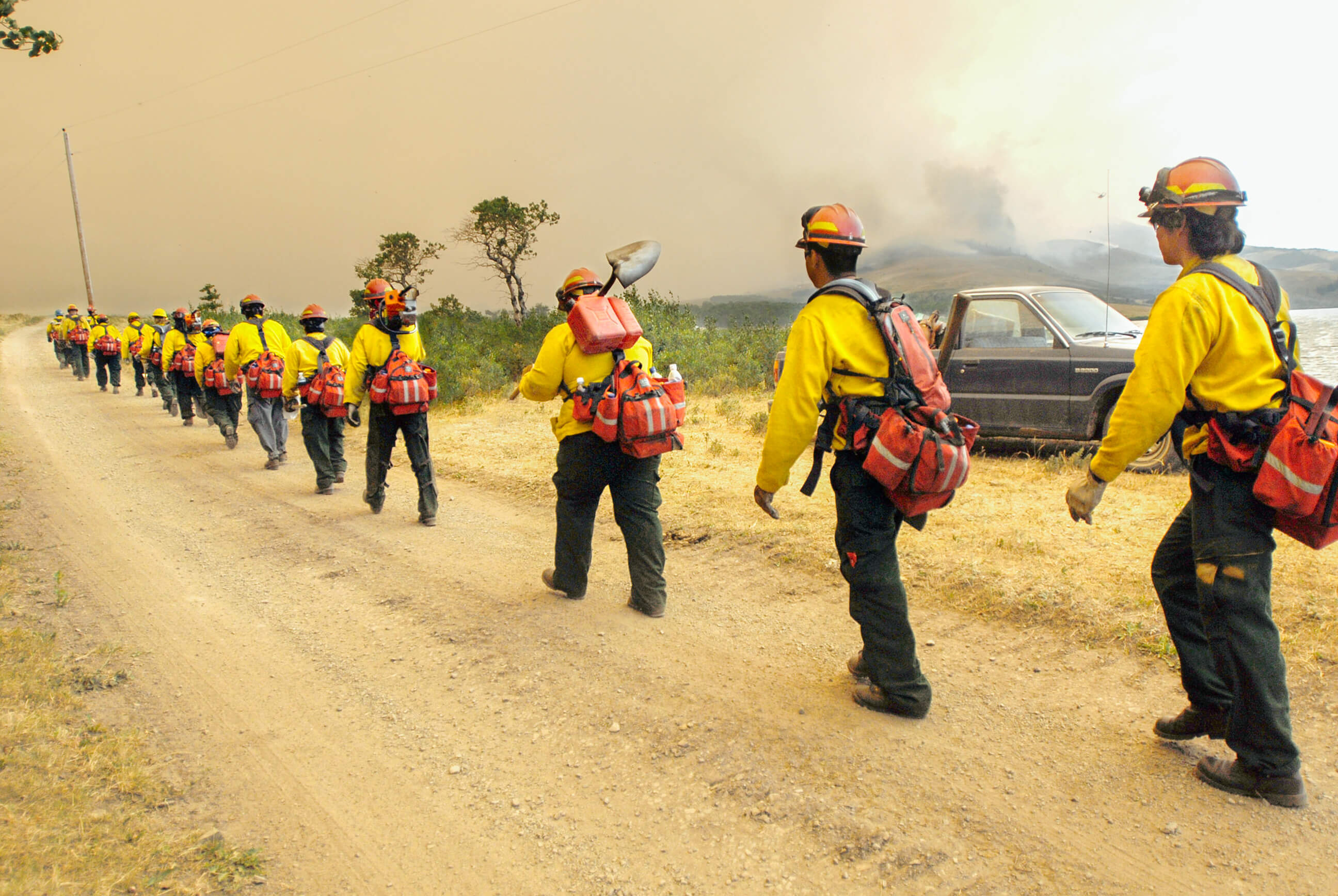 A line of firefighters head to work during a wildfire in Montana
