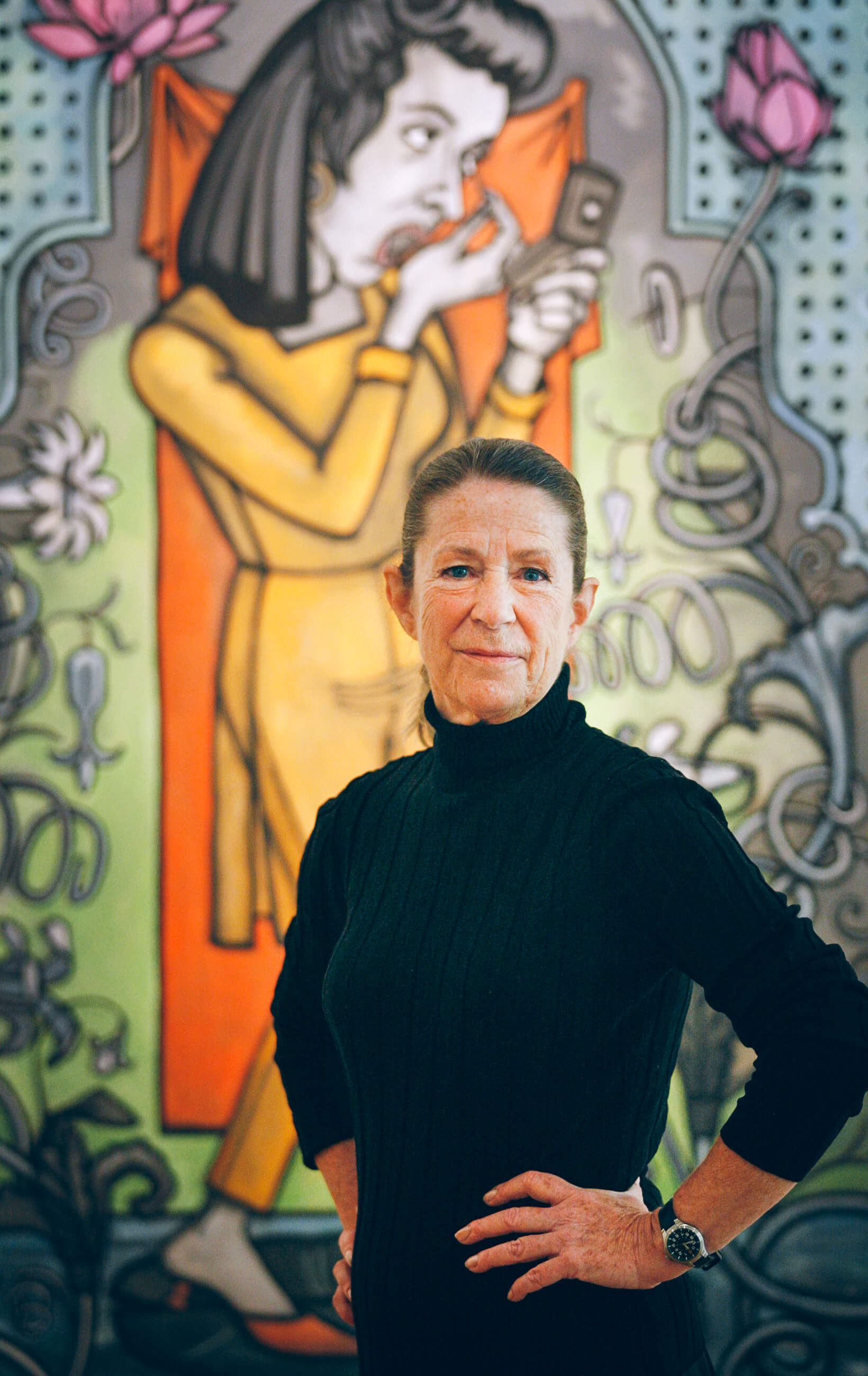 A woman artist stands in front of one of her paintings in Seattle Washington