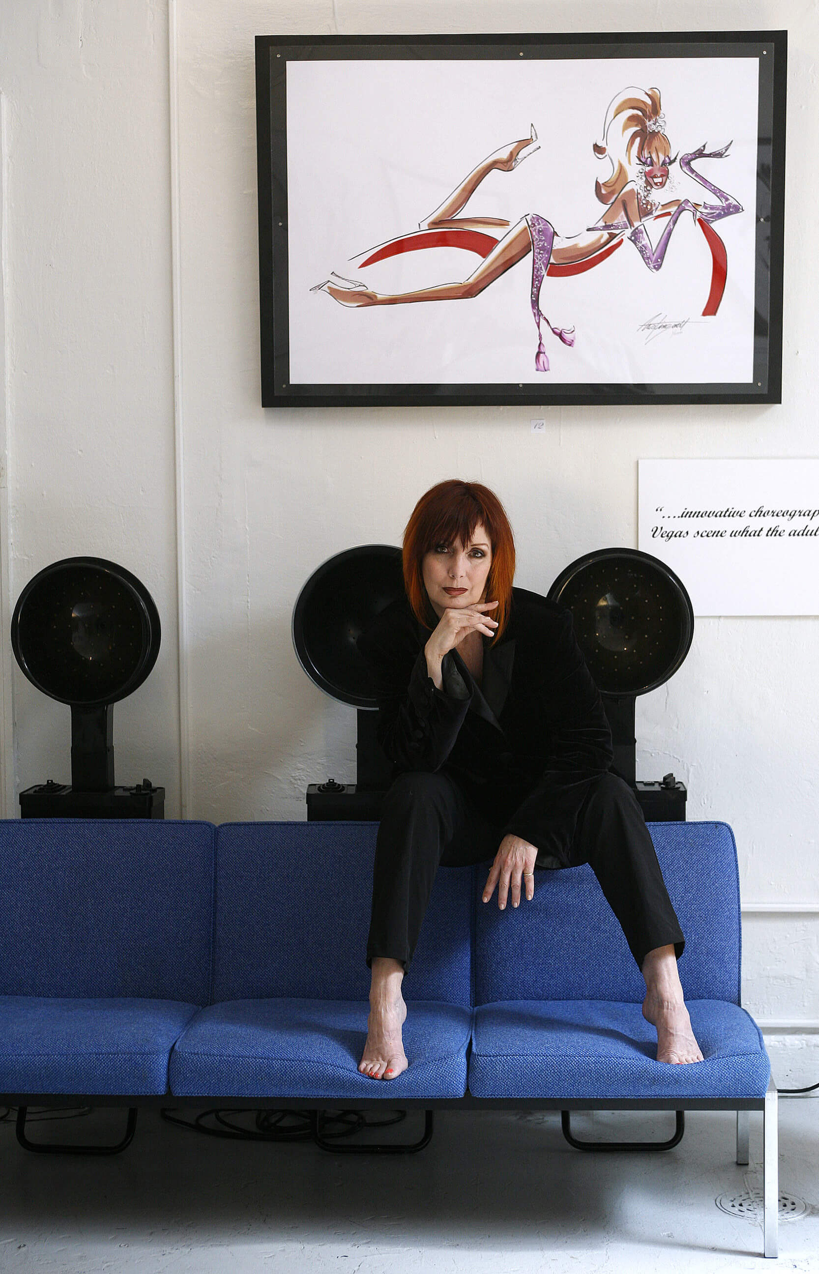 A woman artist sits in a hair salon in front of one of her paintings in Seattle Washington