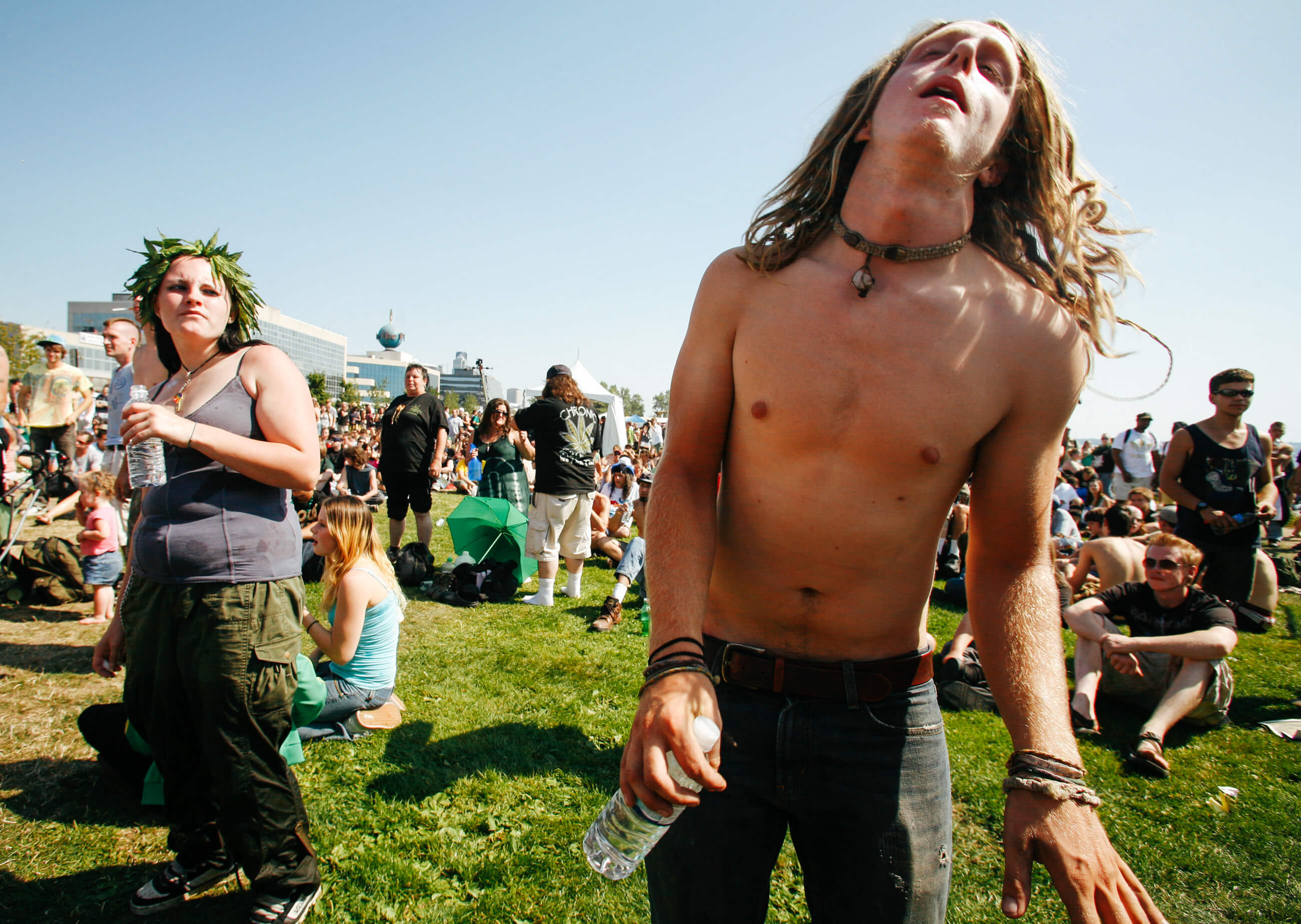 A shirtless man with long hair dances during a musical performance at Hempfest in Seattle Washington