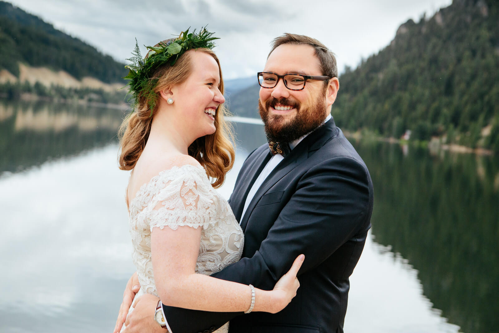 A bride and groom smile and embrace at their elopement at Triple Creek Ranch in Montana