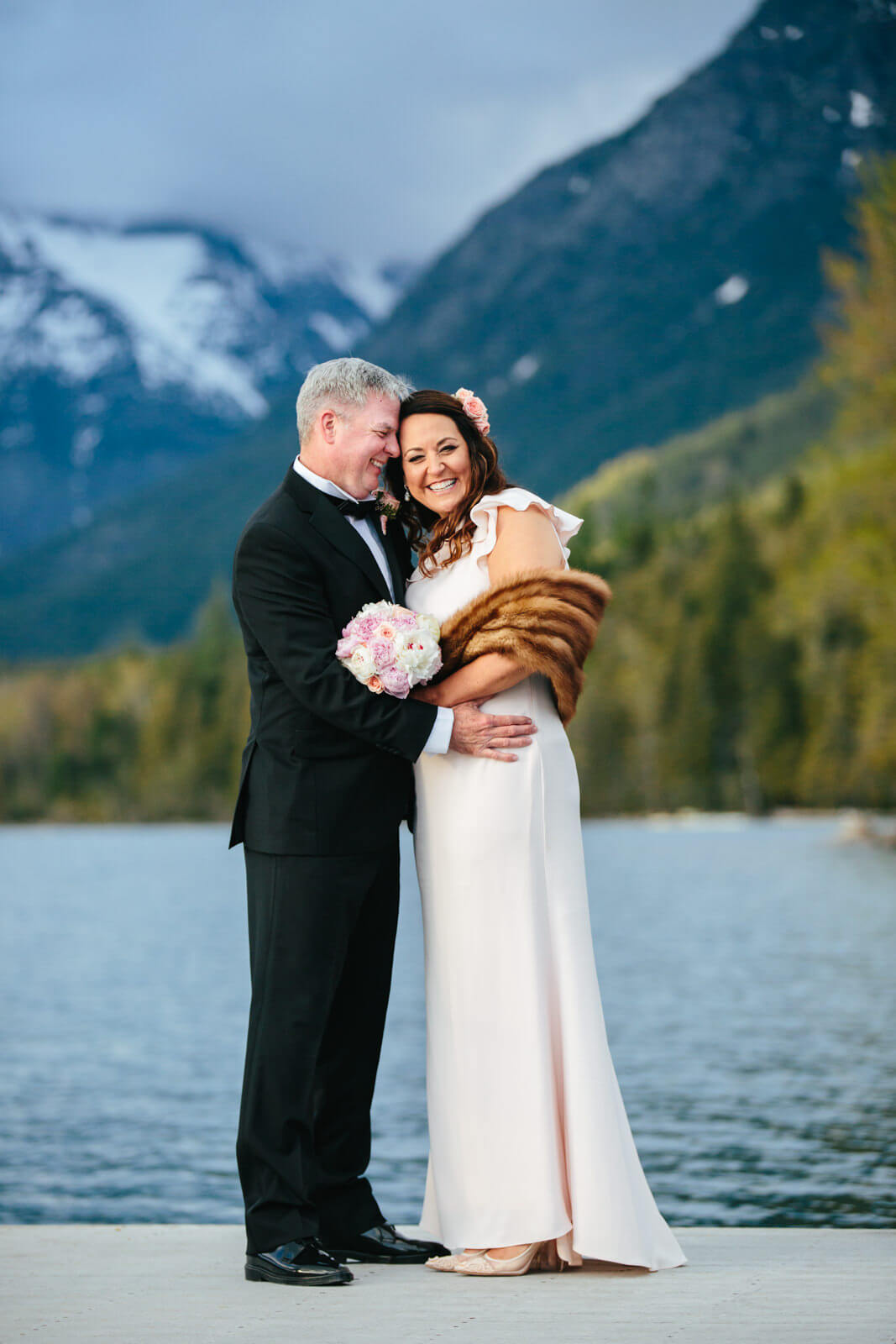 A bride and groom hug and smile during their Glacier National Park elopement in Montana