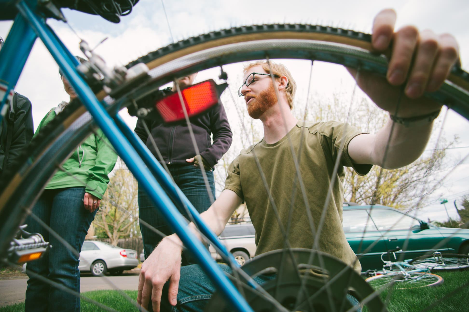 A bicyclist from Portland Oregon examines his friends' bikes in order to encourage them to begin biking more