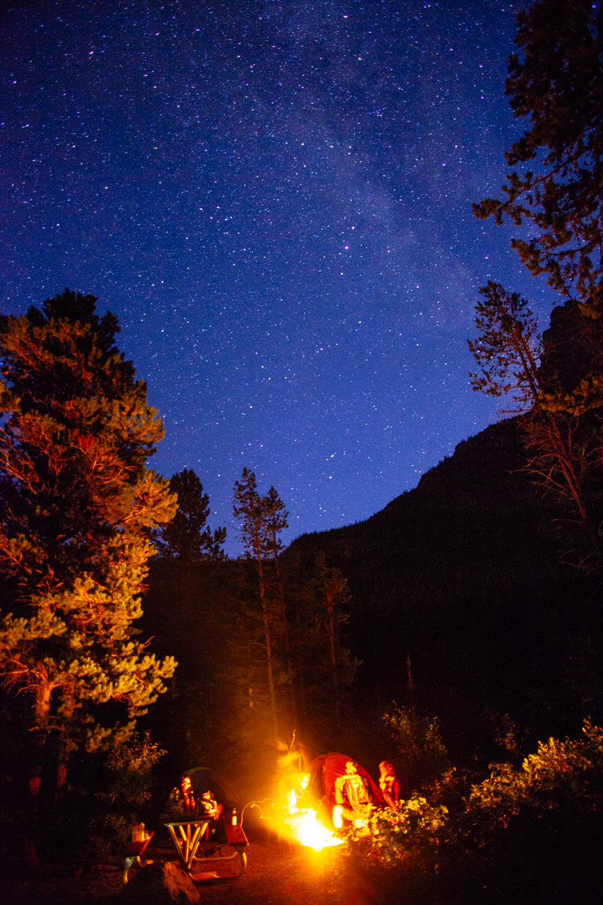 Campers enjoy a campfire at Many Glacier campground in Glacier National Park beneath the Milky way