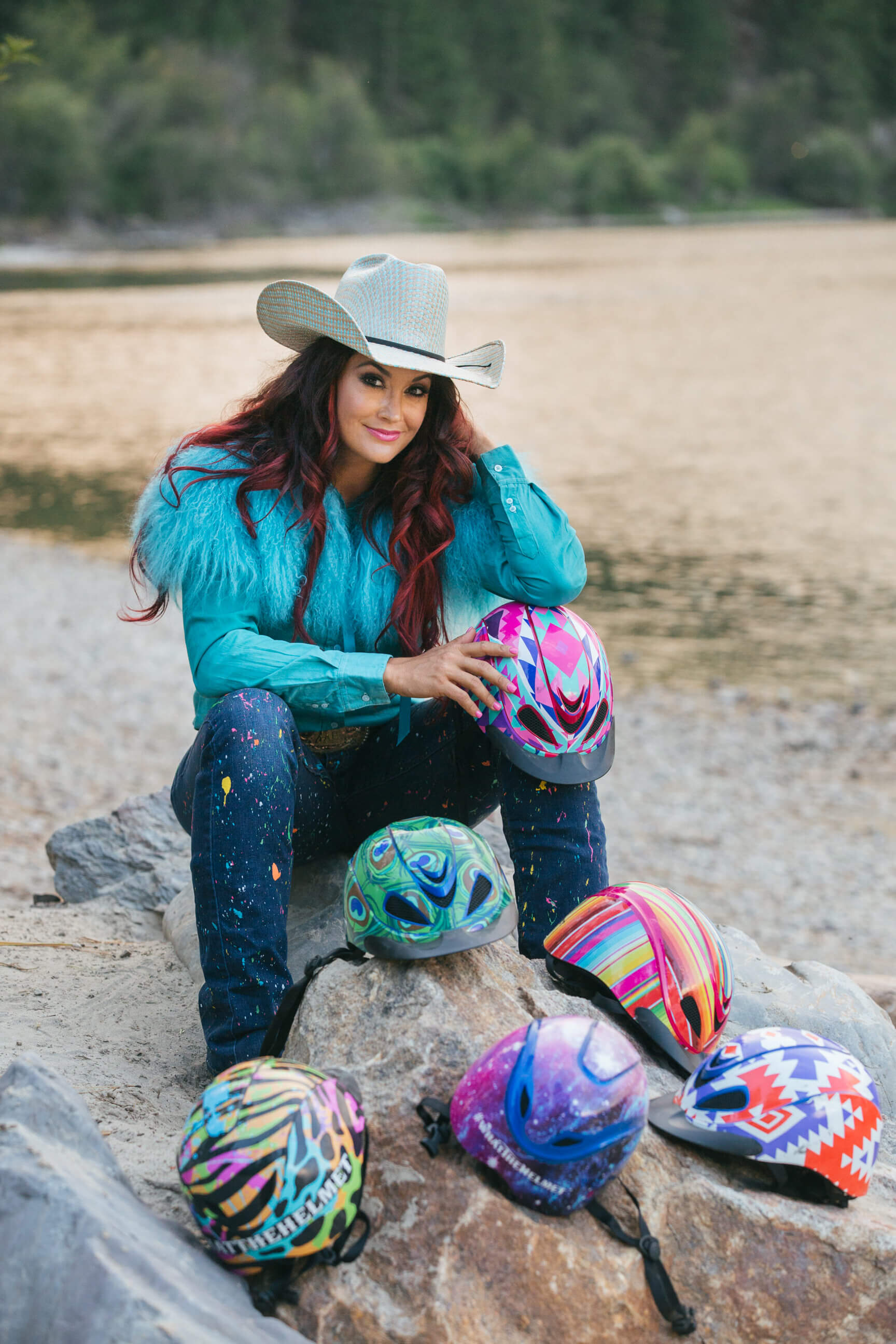 Fallon Taylor poses with her wide variety of helmets that she wears while competing in barrel racing