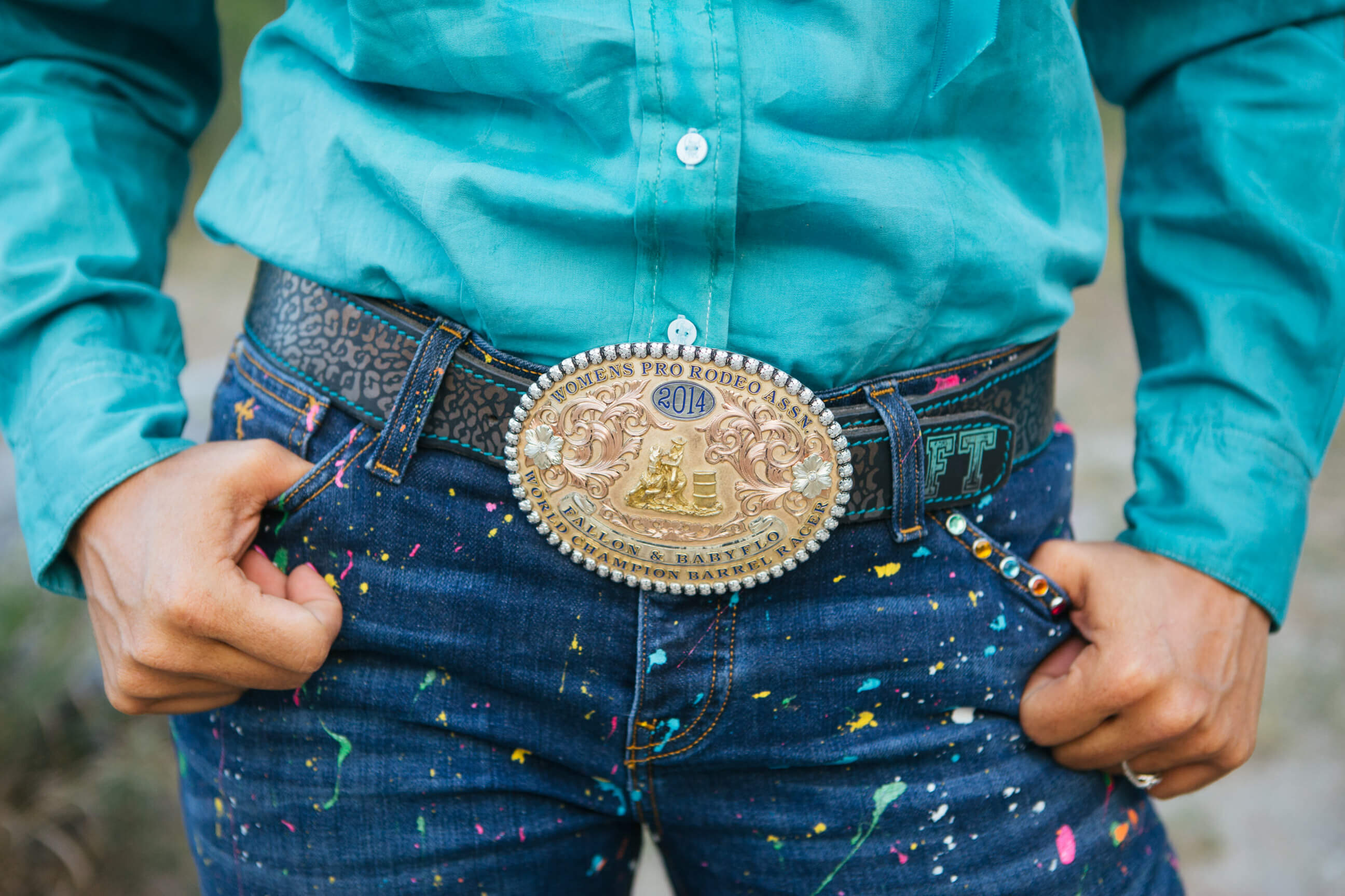 Fallon Taylor sports a large belt buckle and paint spattered pants from her clothing line